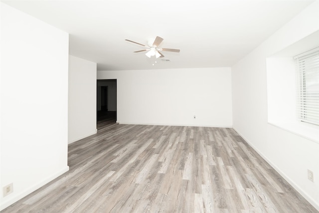 empty room featuring ceiling fan, visible vents, and light wood-type flooring