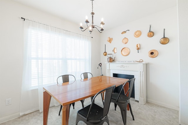 dining area with a notable chandelier, plenty of natural light, and baseboards