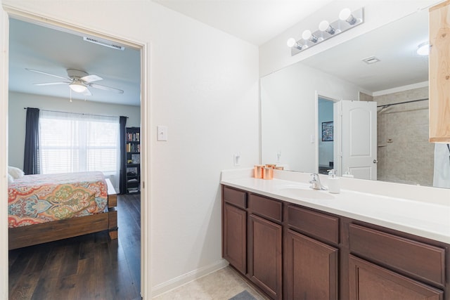 ensuite bathroom with vanity, connected bathroom, wood finished floors, visible vents, and a ceiling fan