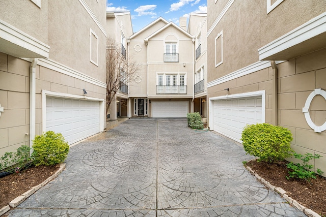 exterior space with stucco siding, driveway, and a garage