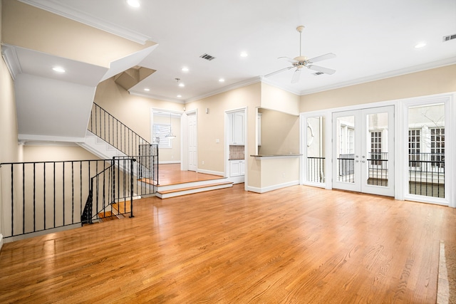 unfurnished living room with french doors, light wood-style flooring, ornamental molding, and visible vents