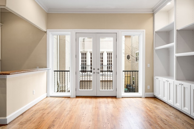 doorway with crown molding, french doors, light wood-style floors, and baseboards