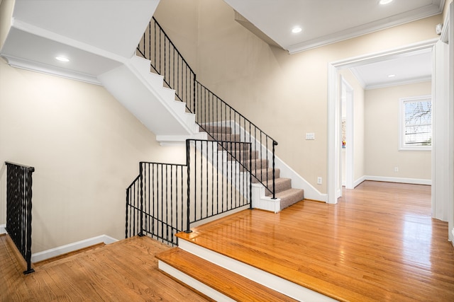 staircase with crown molding, recessed lighting, wood finished floors, and baseboards