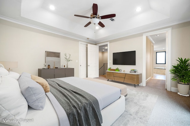 bedroom featuring light colored carpet, baseboards, and a tray ceiling