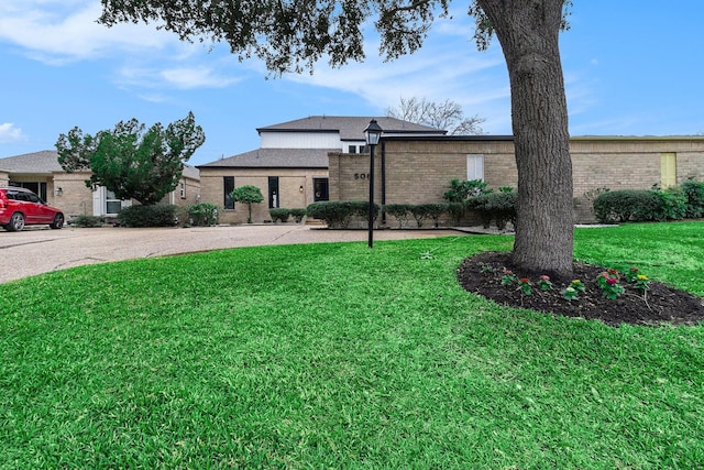 view of front of property with a front lawn and brick siding