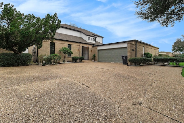 view of front facade with brick siding, driveway, and a garage