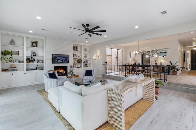 506 Fox Briar Ln, Sugar Land, TX 77478 - living room with light wood-type flooring, ceiling fan, a brick fireplace, recessed lighting, and built in shelves