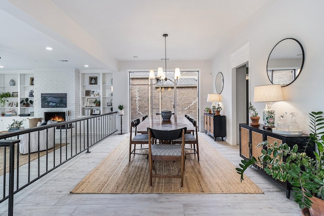 506 Fox Briar Ln, Sugar Land, TX 77478 - dining space with recessed lighting, a chandelier, a fireplace, and light wood-type flooring