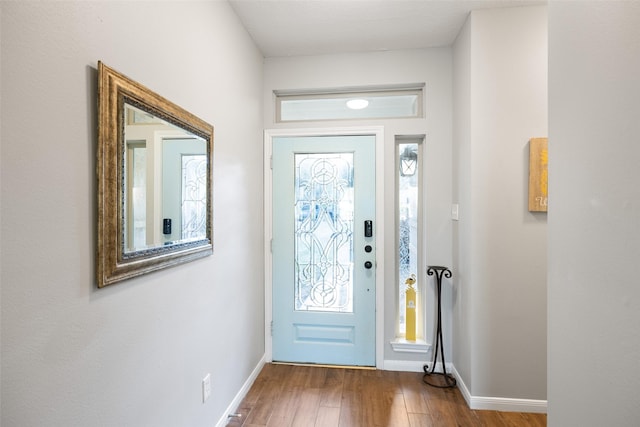 entryway with baseboards and wood finished floors