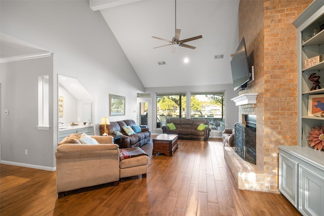 living room featuring wood finished floors, a ceiling fan, baseboards, high vaulted ceiling, and a fireplace