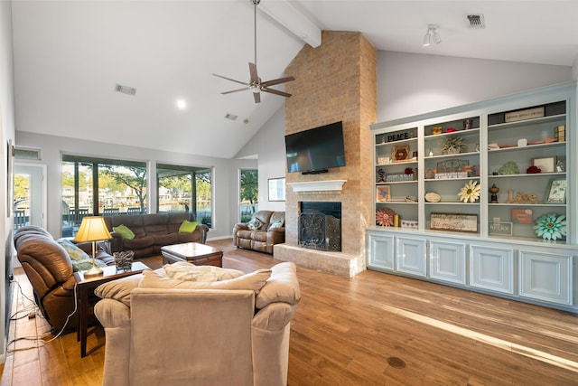 living room featuring light wood-type flooring, visible vents, a brick fireplace, and a healthy amount of sunlight