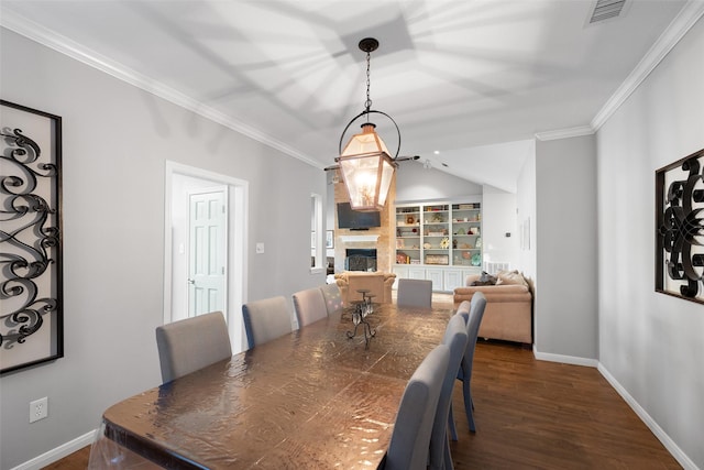 dining area with dark wood-style floors, visible vents, a fireplace, and crown molding