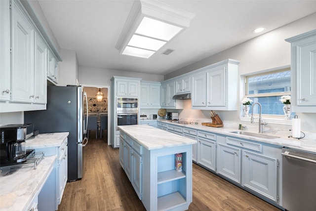 kitchen with a kitchen island, a sink, open shelves, under cabinet range hood, and appliances with stainless steel finishes