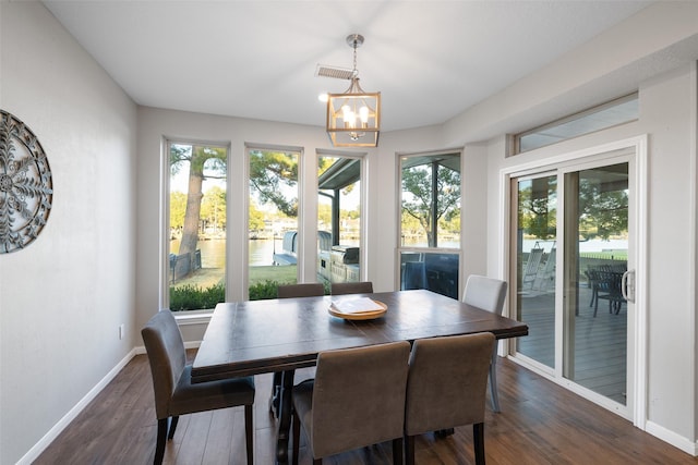 dining room with dark wood finished floors, baseboards, visible vents, and a wealth of natural light