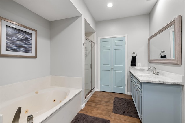 full bathroom with wood finished floors, vanity, a jetted tub, recessed lighting, and a shower stall