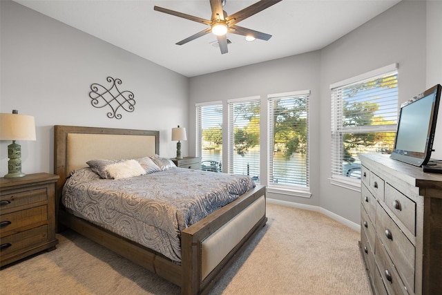 bedroom with a ceiling fan, baseboards, and light carpet