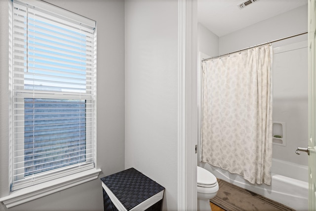 full bathroom with shower / bath combo with shower curtain, visible vents, and toilet