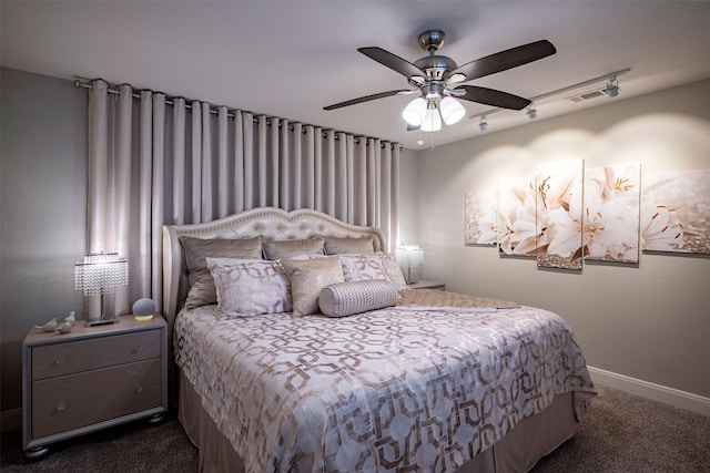 bedroom with visible vents, rail lighting, baseboards, dark colored carpet, and a ceiling fan