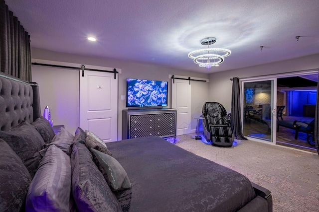 carpeted bedroom with a textured ceiling, access to outside, and a barn door