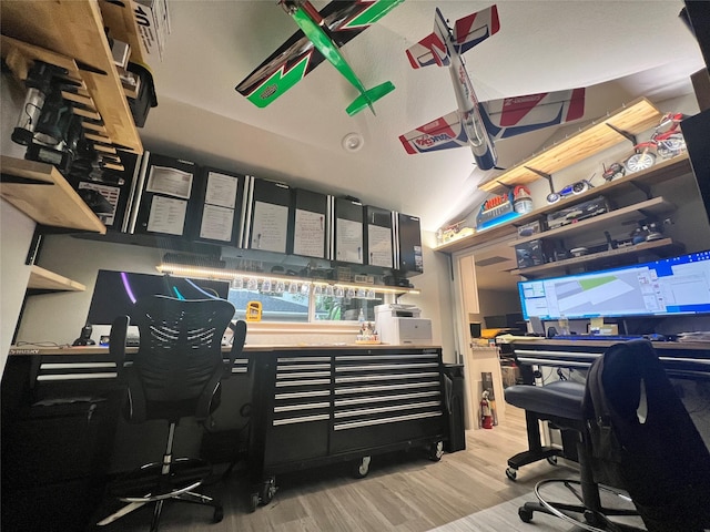 home office featuring wood finished floors and vaulted ceiling