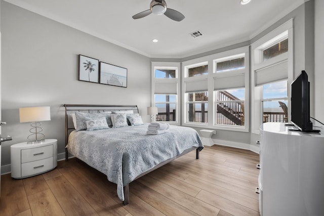 bedroom with light wood-style floors, recessed lighting, crown molding, and baseboards