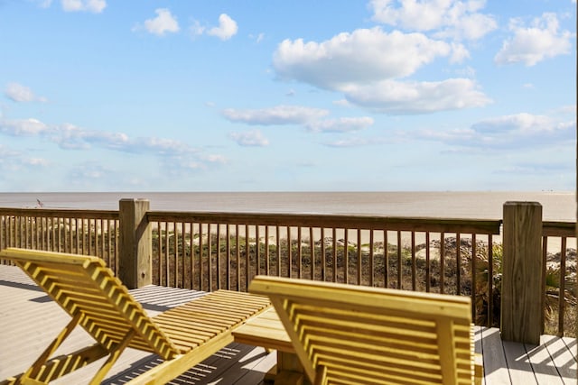 wooden deck with a water view and a view of the beach