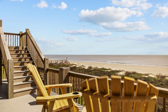 view of home's community with stairs, a water view, and a view of the beach