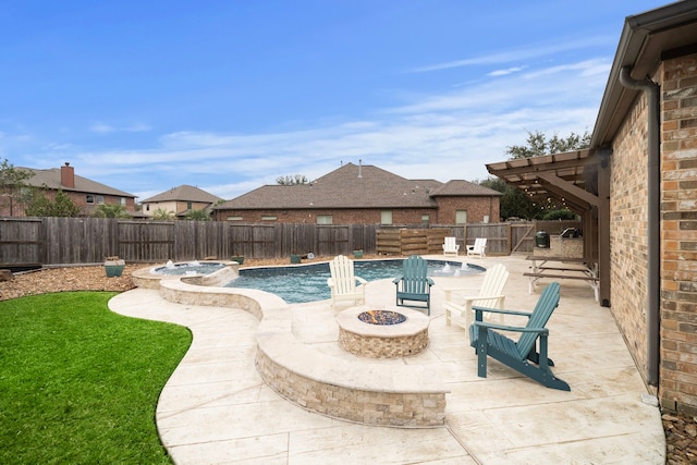 view of pool with a pool with connected hot tub, an outdoor fire pit, a patio area, and a fenced backyard