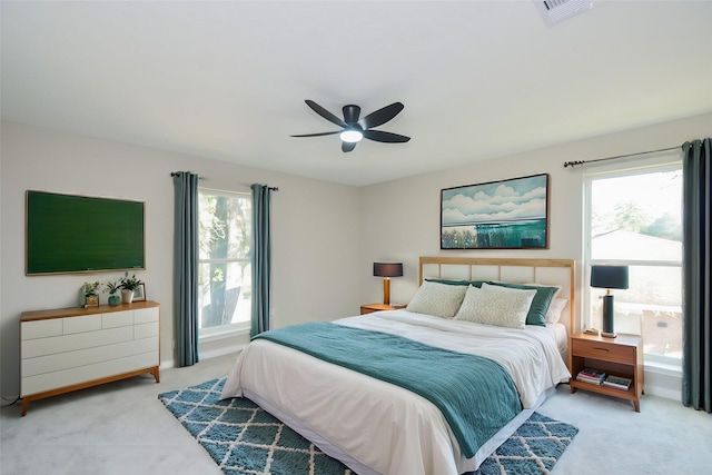 bedroom with visible vents, light carpet, and a ceiling fan