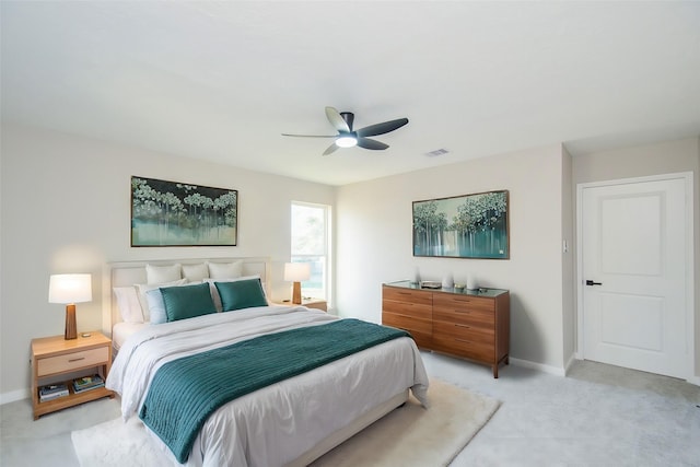 bedroom with baseboards, visible vents, light carpet, and ceiling fan