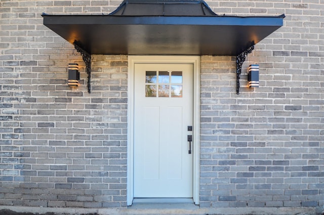 view of exterior entry with brick siding