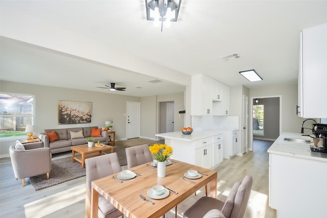 dining space featuring baseboards, a ceiling fan, light wood finished floors, and visible vents