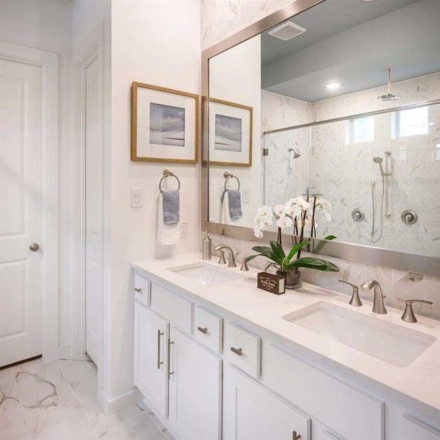 full bath featuring a sink, visible vents, marble finish floor, and double vanity