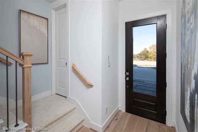 foyer featuring stairs, light wood-style floors, and baseboards