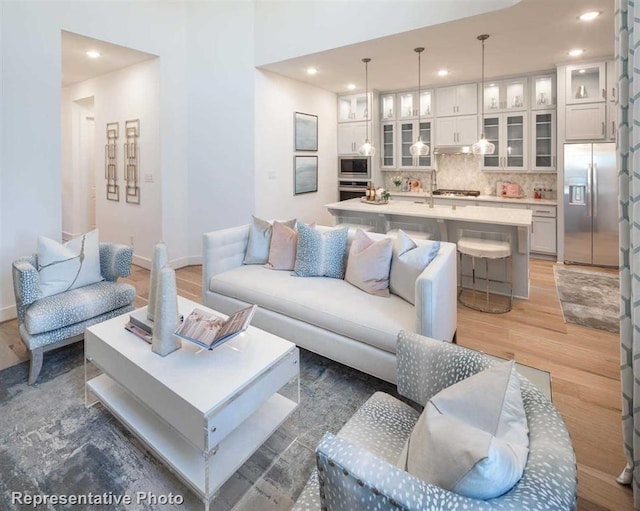 living area featuring dark wood finished floors, baseboards, and recessed lighting