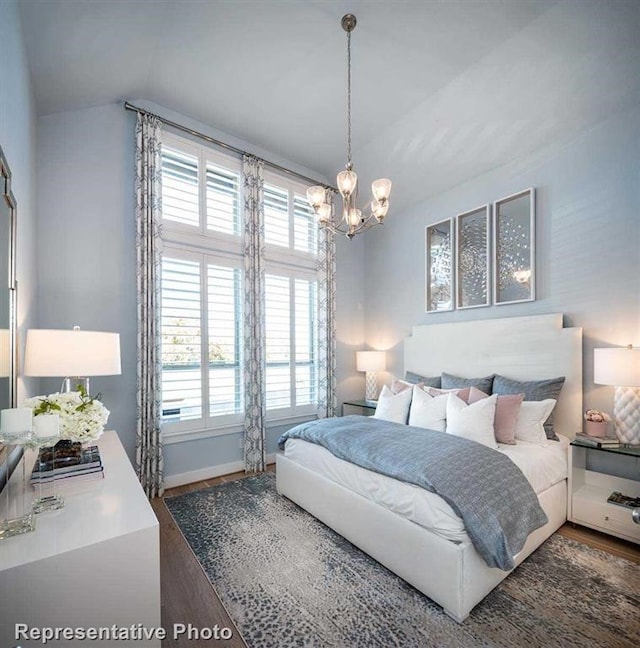 bedroom with a notable chandelier, vaulted ceiling, dark wood-type flooring, and multiple windows