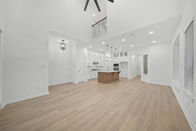 unfurnished living room featuring baseboards, light wood-style floors, recessed lighting, and visible vents