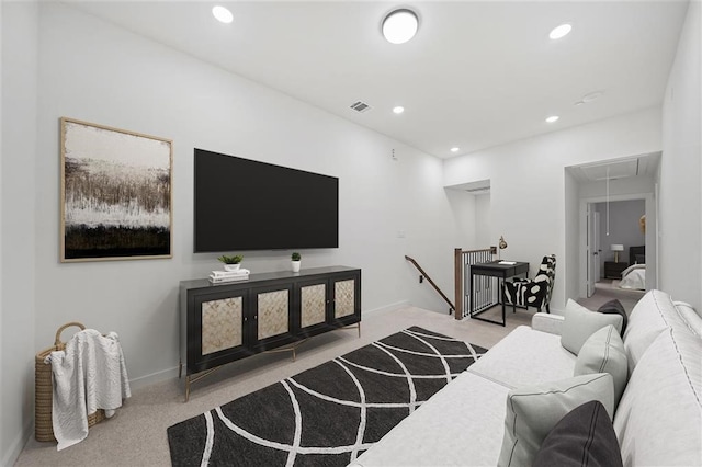 living area featuring attic access, visible vents, light carpet, and recessed lighting