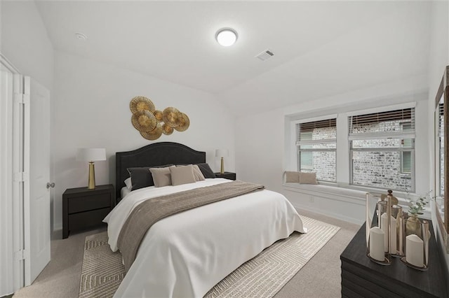 bedroom featuring vaulted ceiling, visible vents, light carpet, and baseboards