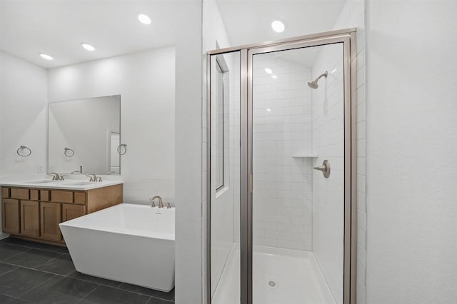 bathroom with double vanity, a stall shower, a freestanding bath, a sink, and tile patterned flooring