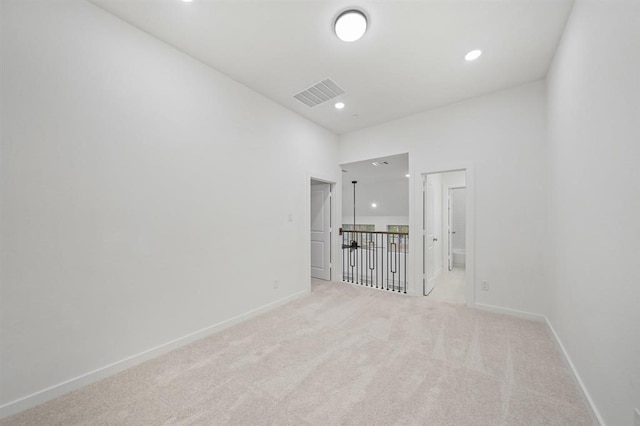 unfurnished room featuring baseboards, visible vents, recessed lighting, and light carpet