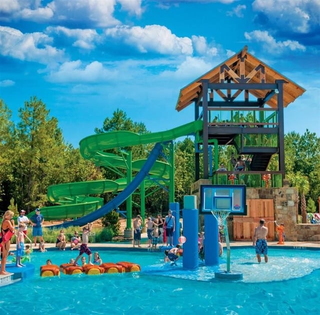 view of jungle gym featuring a community pool and a water play area