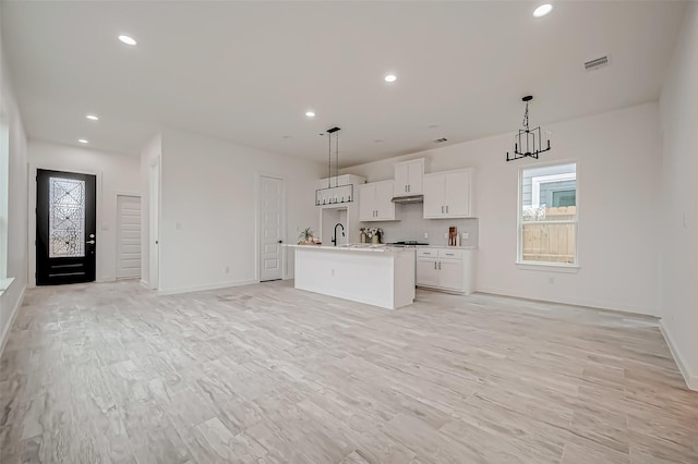 9418 Madera Rd, Houston, TX 77078 - kitchen featuring open floor plan, baseboards, white cabinets, a kitchen island with sink, and recessed lighting