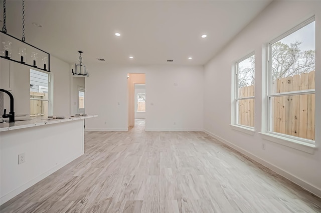 9418 Madera Rd, Houston, TX 77078 - unfurnished living room featuring light wood-style floors, recessed lighting, baseboards, and a chandelier
