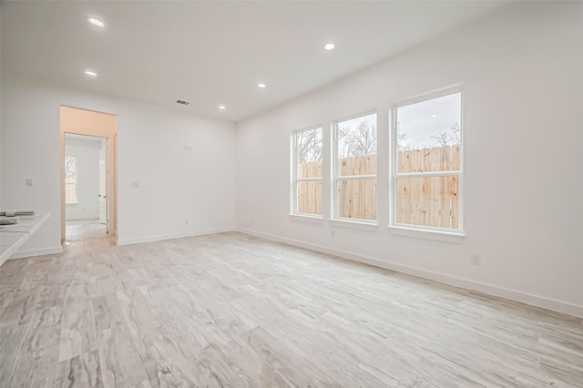 9418 Madera Rd, Houston, TX 77078 - empty room with plenty of natural light, recessed lighting, light wood finished floors, and baseboards