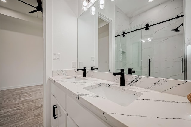 9418 Madera Rd, Houston, TX 77078 - full bath with a marble finish shower, double vanity, wood finished floors, baseboards, and a ceiling fan