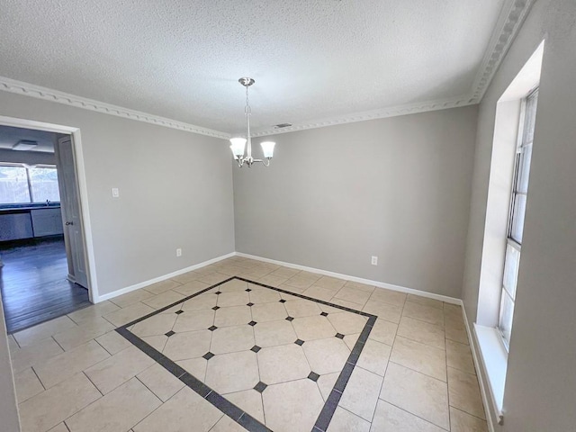 spare room featuring light tile patterned floors, a textured ceiling, and baseboards