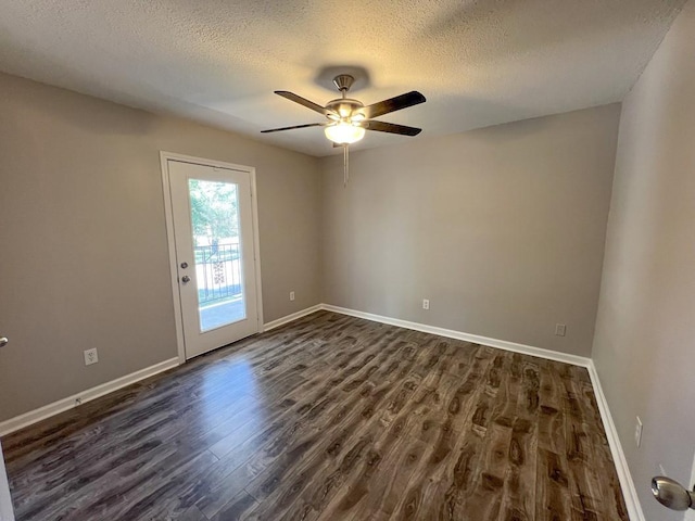 empty room featuring baseboards, dark wood finished floors, and a textured ceiling