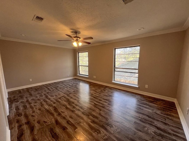 spare room with ornamental molding, dark wood finished floors, visible vents, and baseboards