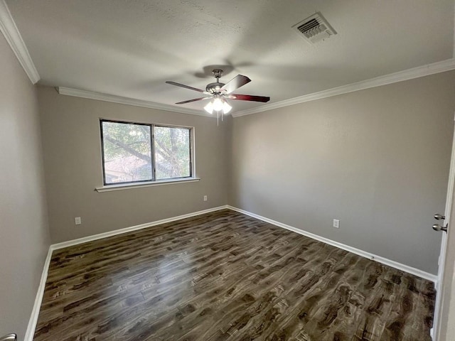 empty room with dark wood finished floors, visible vents, ornamental molding, a ceiling fan, and baseboards